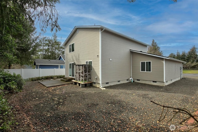 back of house with crawl space and fence