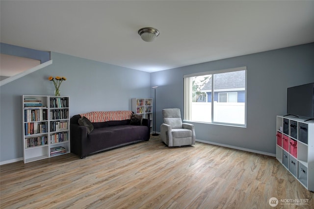 living area with light wood-type flooring and baseboards