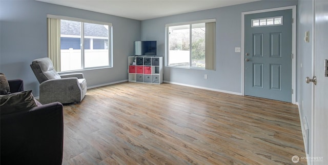 living area featuring baseboards and wood finished floors