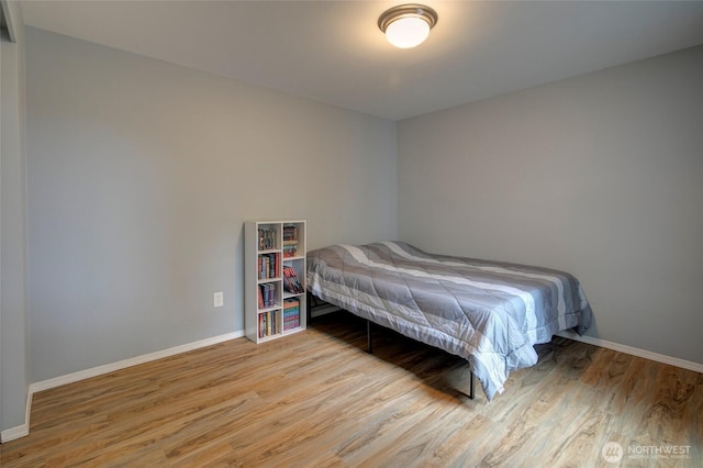 bedroom featuring light wood-style floors and baseboards