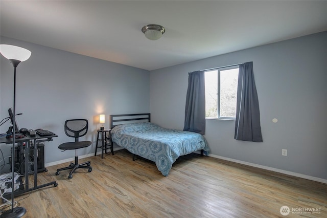 bedroom featuring baseboards and wood finished floors
