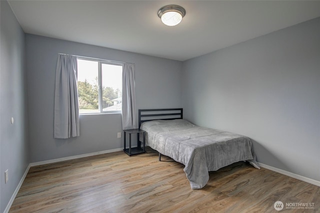 bedroom featuring baseboards and wood finished floors