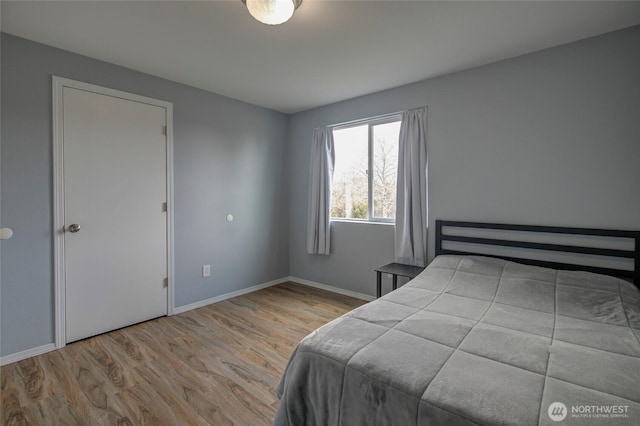 bedroom with baseboards and wood finished floors