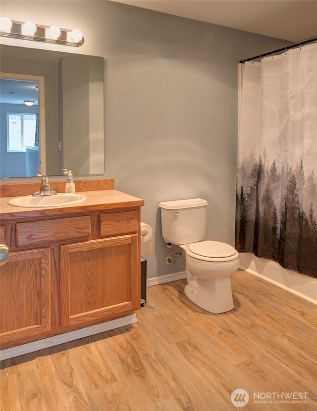 bathroom featuring vanity, a shower with shower curtain, toilet, and wood finished floors