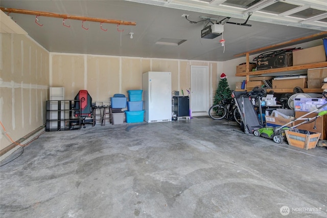 garage with a garage door opener and freestanding refrigerator
