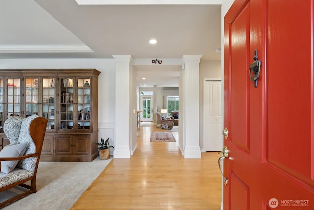 foyer featuring ornate columns, baseboards, recessed lighting, and light wood-style floors