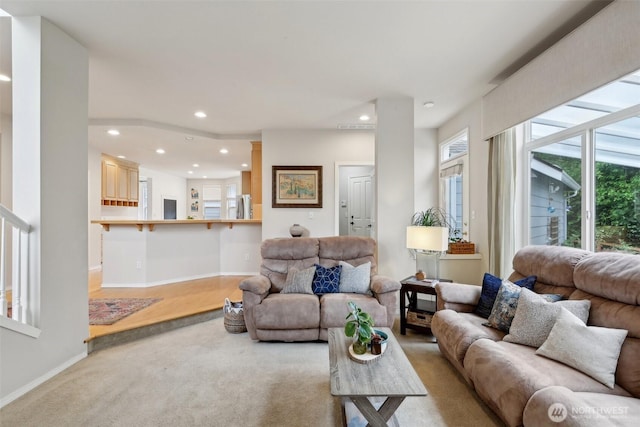 living area featuring baseboards, light carpet, and recessed lighting