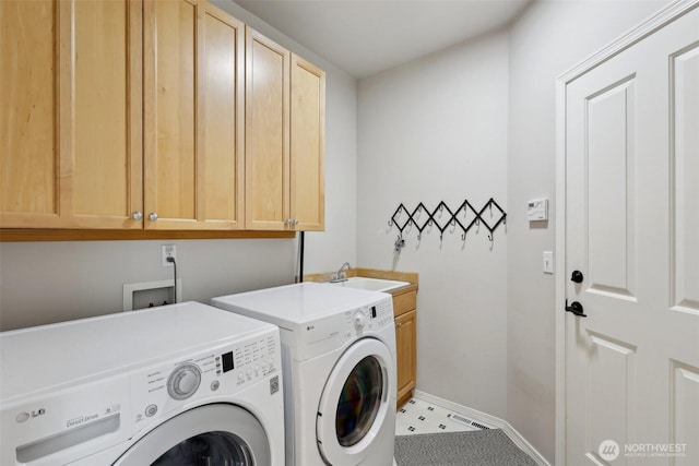 washroom featuring visible vents, washing machine and clothes dryer, cabinet space, a sink, and baseboards