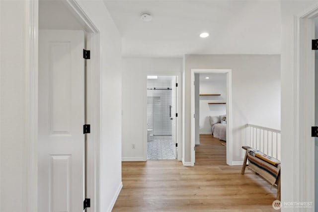 hall featuring light wood-style floors, recessed lighting, and baseboards
