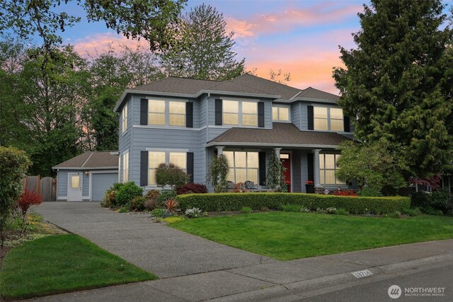 view of front of property featuring a garage, fence, a shingled roof, and a front lawn