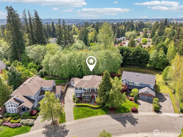 drone / aerial view featuring a residential view and a wooded view