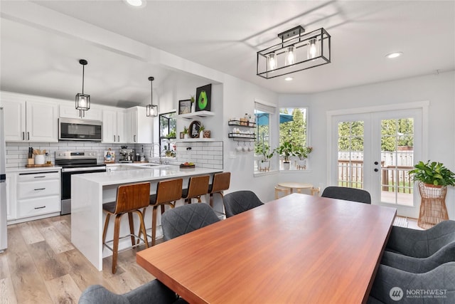 dining area with recessed lighting, light wood-style floors, and french doors