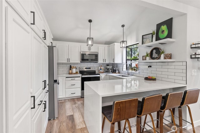 kitchen with decorative backsplash, a peninsula, stainless steel appliances, and a sink