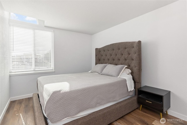 bedroom with wood finished floors and baseboards