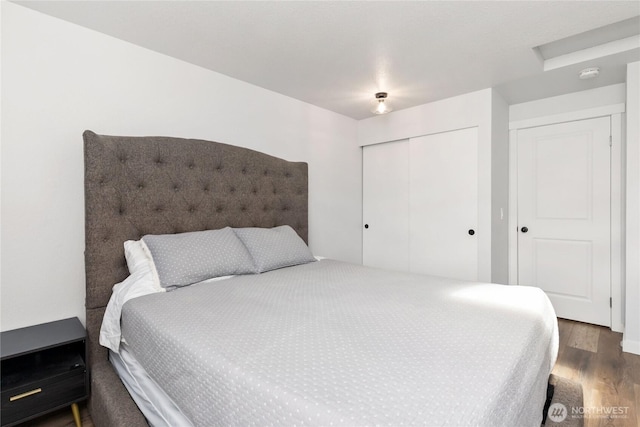 bedroom featuring attic access, wood finished floors, and a closet