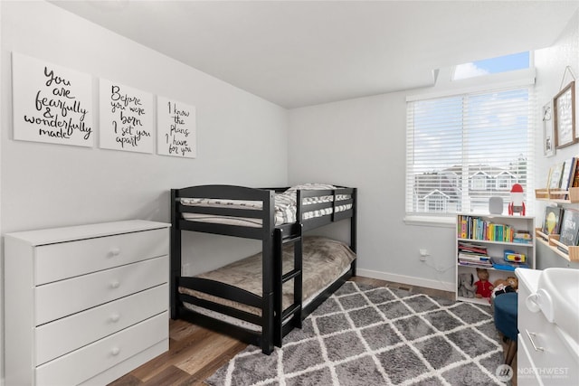 bedroom with dark wood-type flooring and baseboards