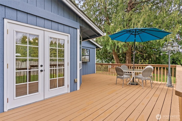 wooden terrace with outdoor dining space and french doors