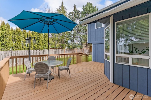 wooden terrace with outdoor dining space and fence private yard