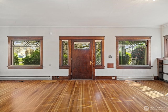 entrance foyer with ornamental molding, wood finished floors, baseboards, and a baseboard radiator