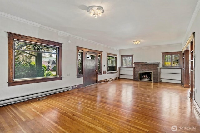 unfurnished living room featuring a baseboard radiator, wood finished floors, a fireplace, and crown molding