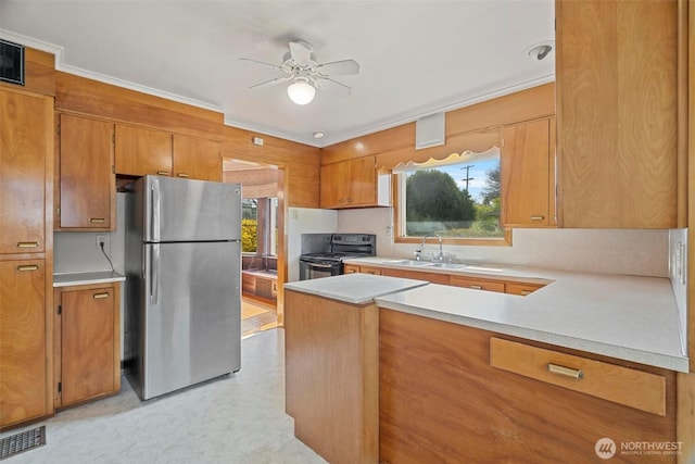 kitchen featuring black electric range, a sink, freestanding refrigerator, brown cabinetry, and ceiling fan