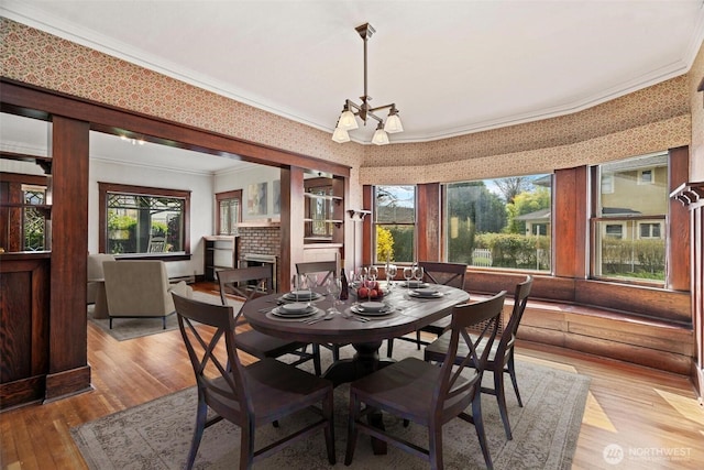dining room featuring plenty of natural light, light wood-type flooring, and crown molding