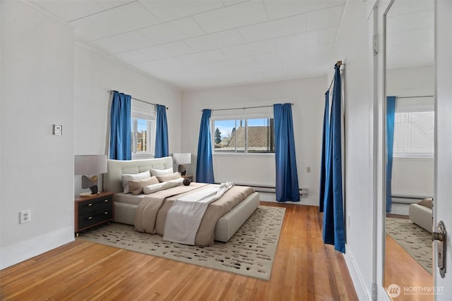 bedroom with baseboards and wood finished floors