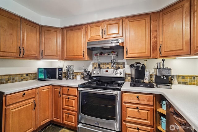 kitchen featuring under cabinet range hood, stainless steel appliances, light countertops, and brown cabinets