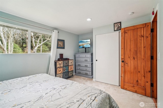 bedroom with light colored carpet, a closet, and recessed lighting