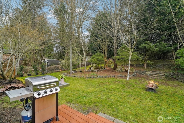 view of yard featuring an outdoor fire pit and a deck