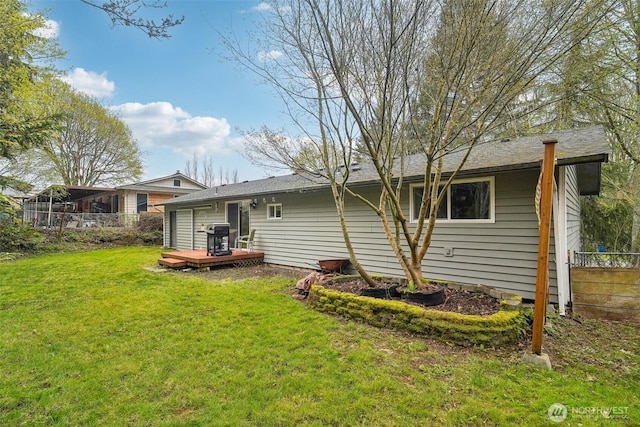 back of house with a lawn, a deck, and fence