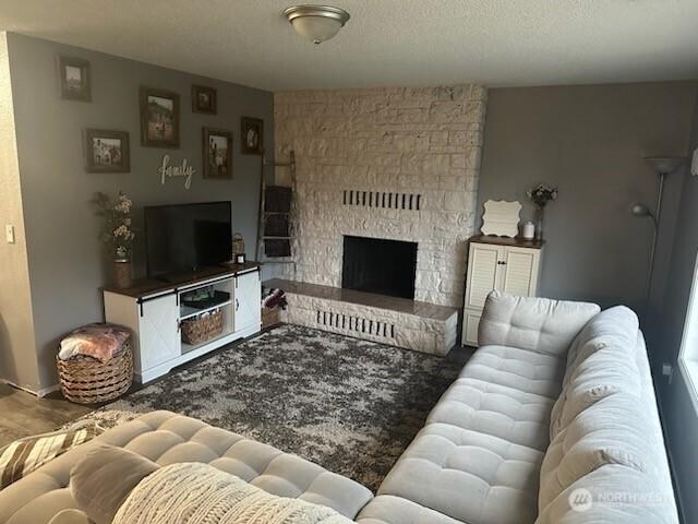 310 Kosmos Ln, Morton, WA 98356 - living area featuring a stone fireplace and a textured ceiling