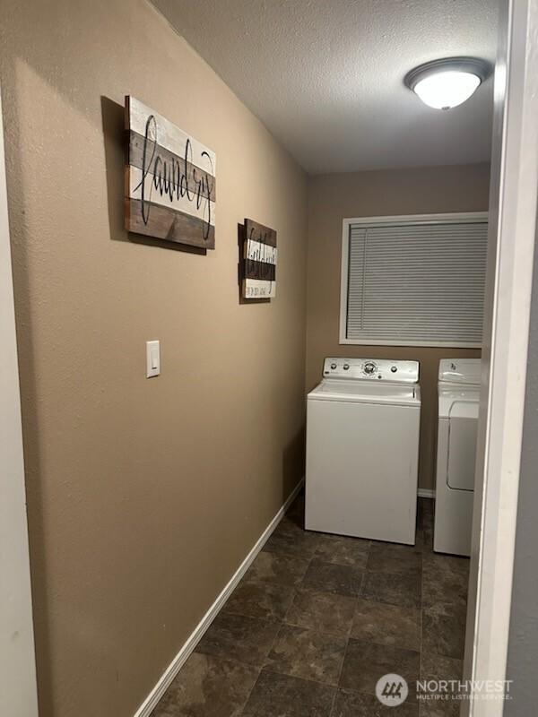 310 Kosmos Ln, Morton, WA 98356 - clothes washing area featuring washing machine and clothes dryer, laundry area, a textured ceiling, and baseboards