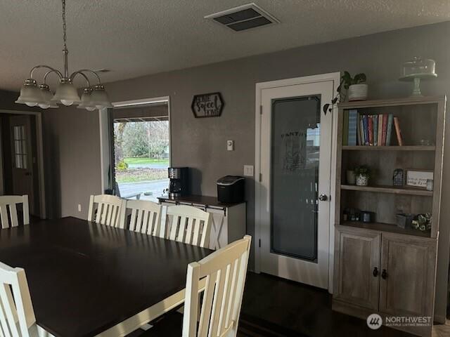 310 Kosmos Ln, Morton, WA 98356 - dining area with a notable chandelier, visible vents, and a textured ceiling