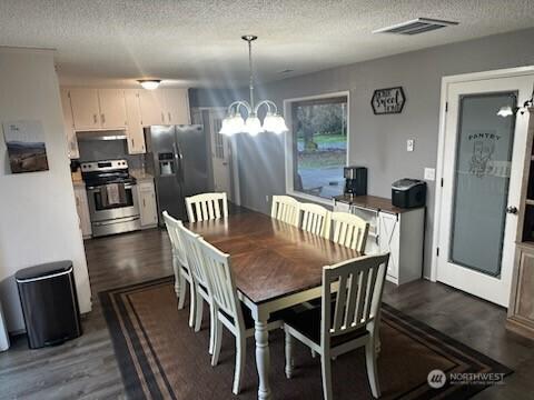 310 Kosmos Ln, Morton, WA 98356 - dining area with a chandelier, visible vents, a textured ceiling, and dark wood-type flooring