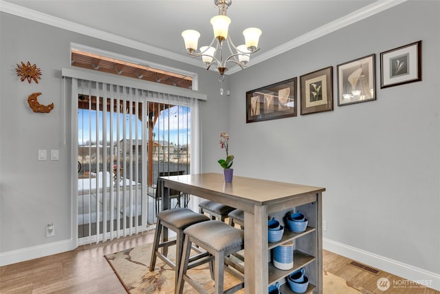 404 Airport Way SW, Mattawa, WA 99349 - dining area featuring baseboards, visible vents, light wood finished floors, crown molding, and a notable chandelier