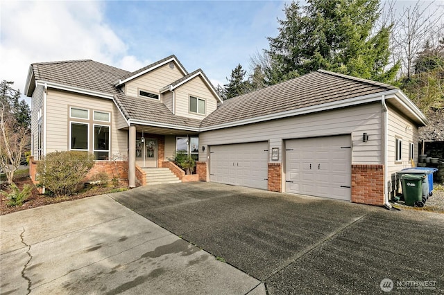 view of front facade with a tiled roof, a garage, brick siding, and driveway