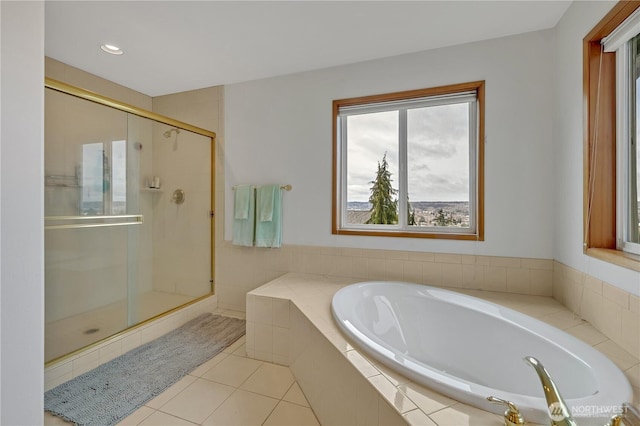 bathroom featuring a bath, tile patterned flooring, and a shower stall