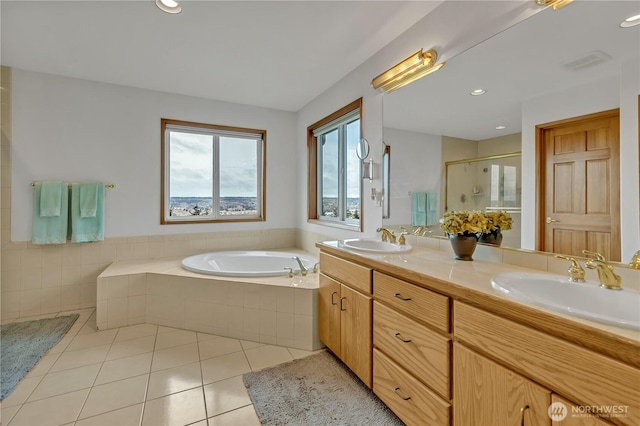 bathroom with tile patterned floors, a garden tub, a shower stall, and a sink