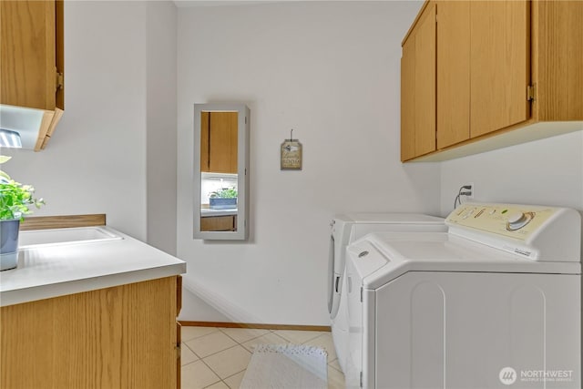 laundry area with light tile patterned floors, cabinet space, independent washer and dryer, and baseboards