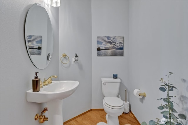 bathroom featuring baseboards, toilet, and wood finished floors