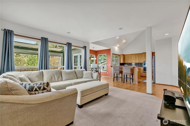 living room featuring lofted ceiling, recessed lighting, light wood-style floors, and baseboards