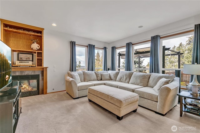 living area featuring recessed lighting, baseboards, light carpet, and a tiled fireplace