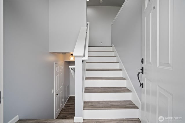 stairway featuring wood finished floors and baseboards