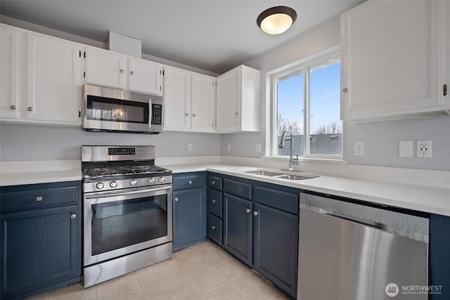 kitchen featuring a sink, blue cabinets, white cabinetry, and stainless steel appliances