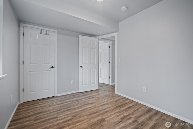 unfurnished bedroom featuring baseboards and wood finished floors