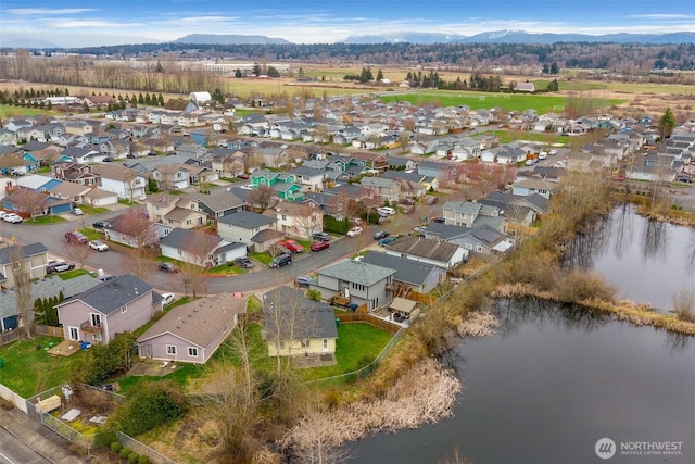 drone / aerial view featuring a residential view and a water and mountain view