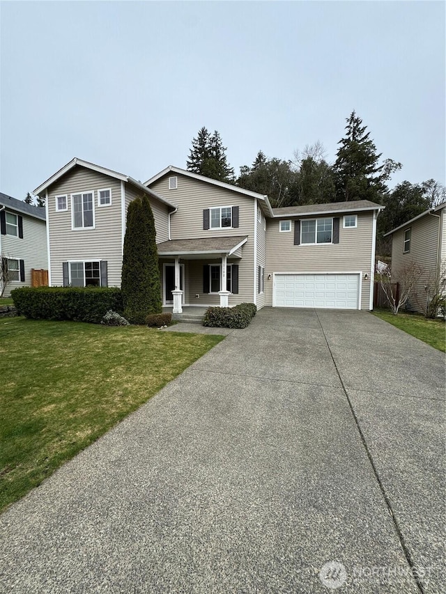 traditional-style home with a front lawn, an attached garage, covered porch, and concrete driveway