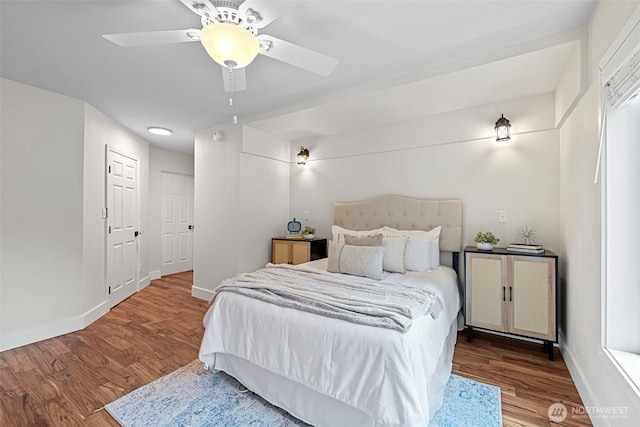 bedroom with baseboards, wood finished floors, and a ceiling fan