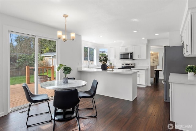 dining space featuring dark wood-type flooring, visible vents, recessed lighting, and a notable chandelier
